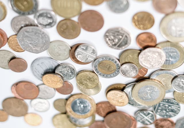 A Picture with lots of coins on a white Table.